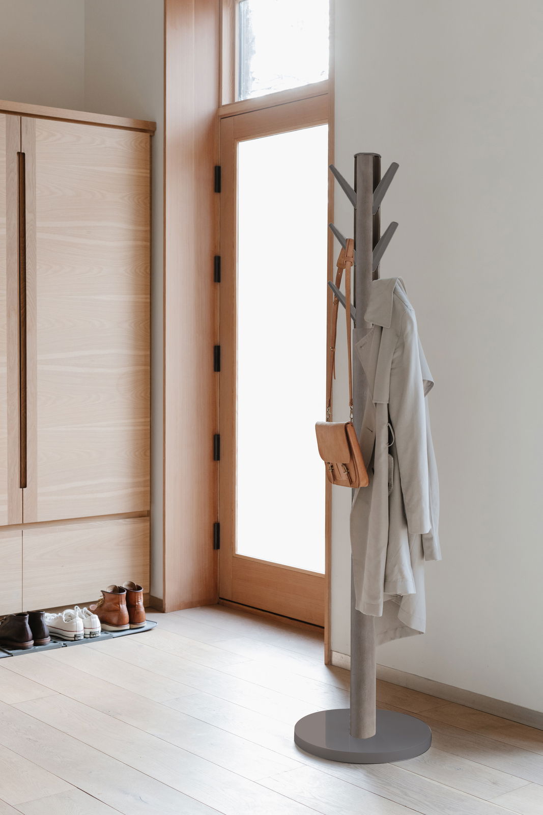 Moderner Garderobenständer aus Metall in einem hellen Flur, seitliche Perspektive