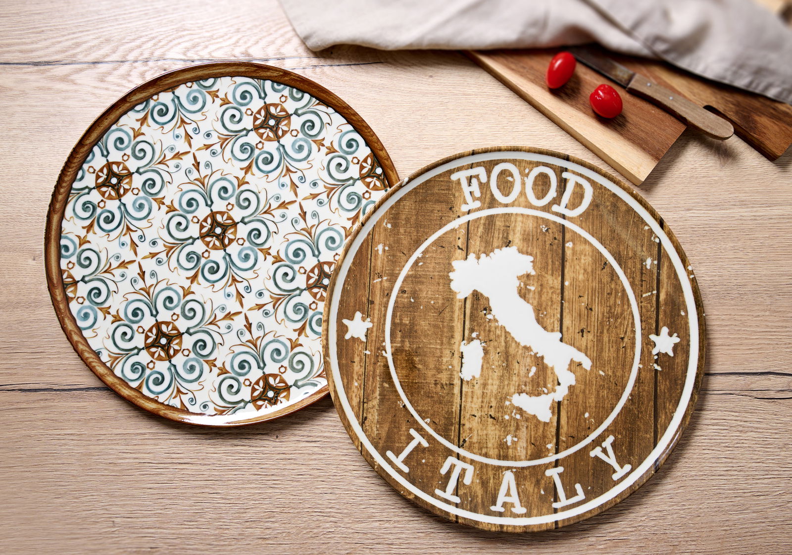 Zwei Pizzateller aus der Vogelperspektive: Einer mit floralem Muster in Grün und Braun, der andere mit rustikalem Holzdesign und Italien-Motiv.