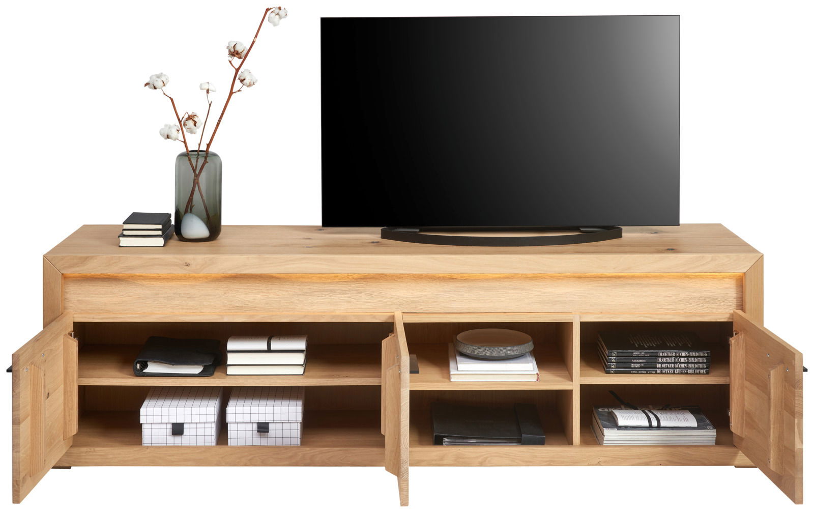 Frontale Ansicht eines TV-Lowboards aus Holz mit offenen Türen, dekoriert mit Büchern, Boxen und einer Vase mit Zweigen.
