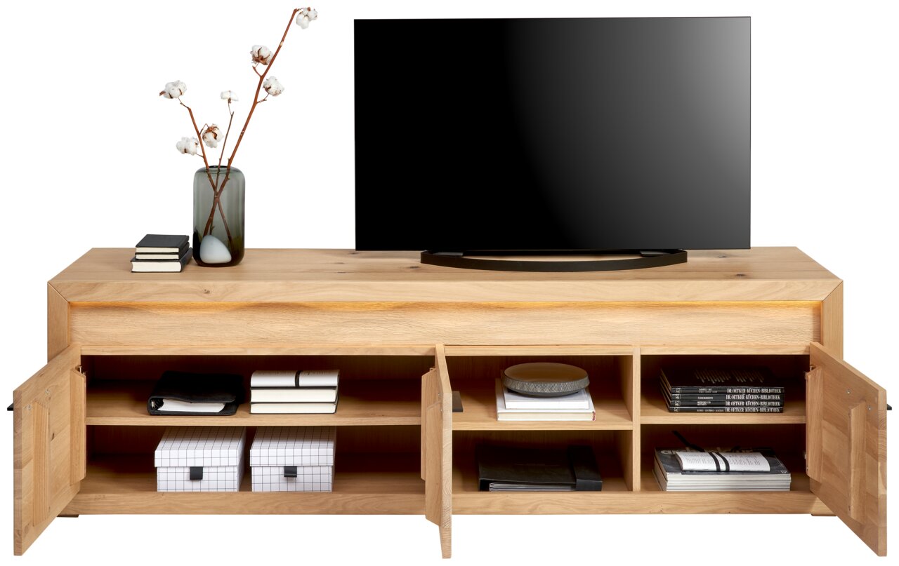 Frontale Ansicht eines TV-Lowboards aus Holz mit offenen Türen, dekoriert mit Büchern, Boxen und einer Vase mit Zweigen.