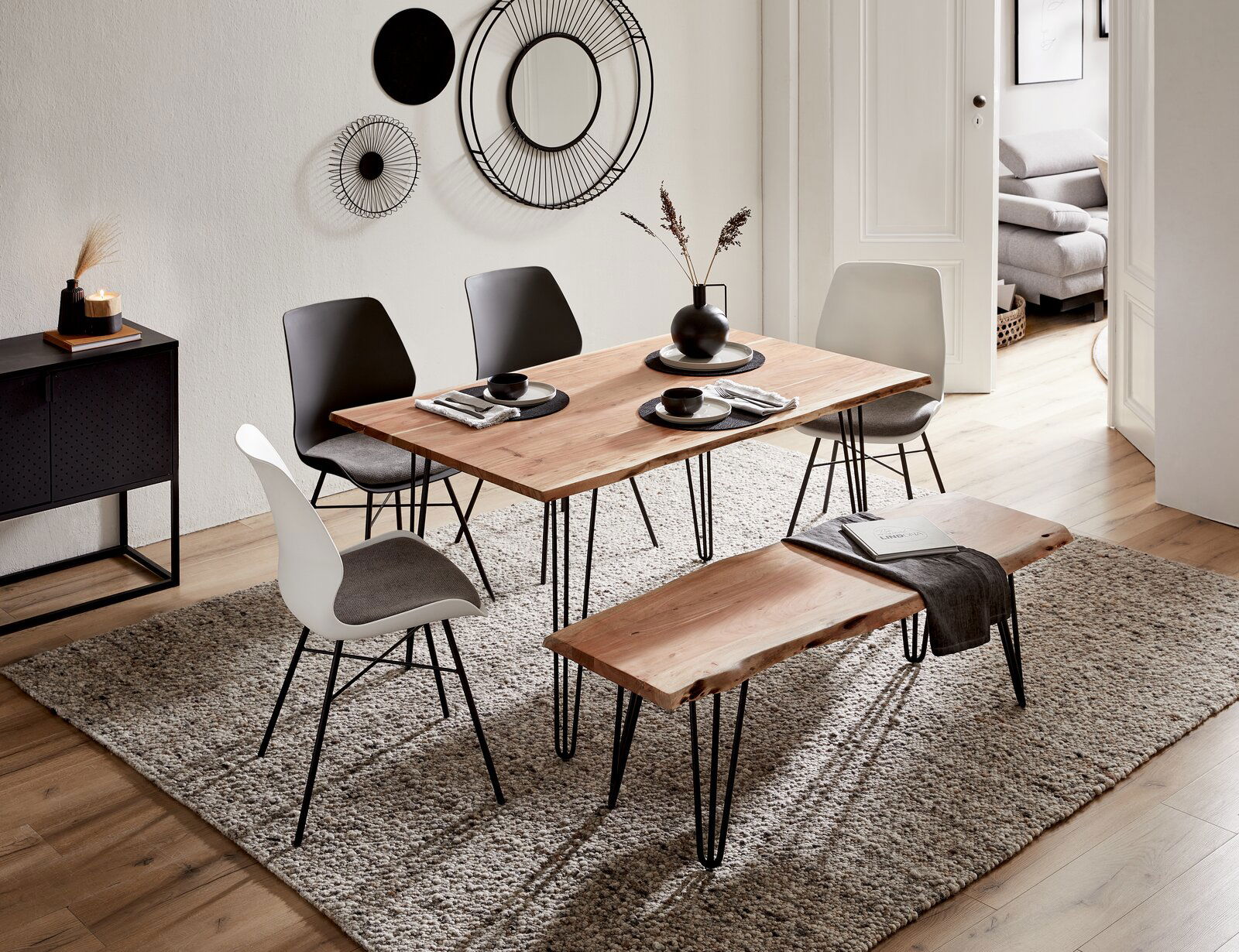 Moderner Essbereich mit Holztisch und passender Bank, umgeben von stilvollen Stühlen, aus der Vogelperspektive fotografiert.