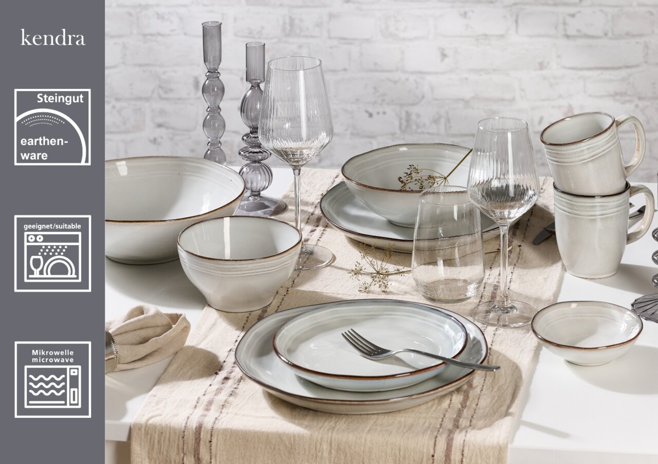 Frühstücksset aus Steingut, bestehend aus Tellern, Schalen und Tassen in einer eleganten Tischdekoration, seitliche Perspektive.