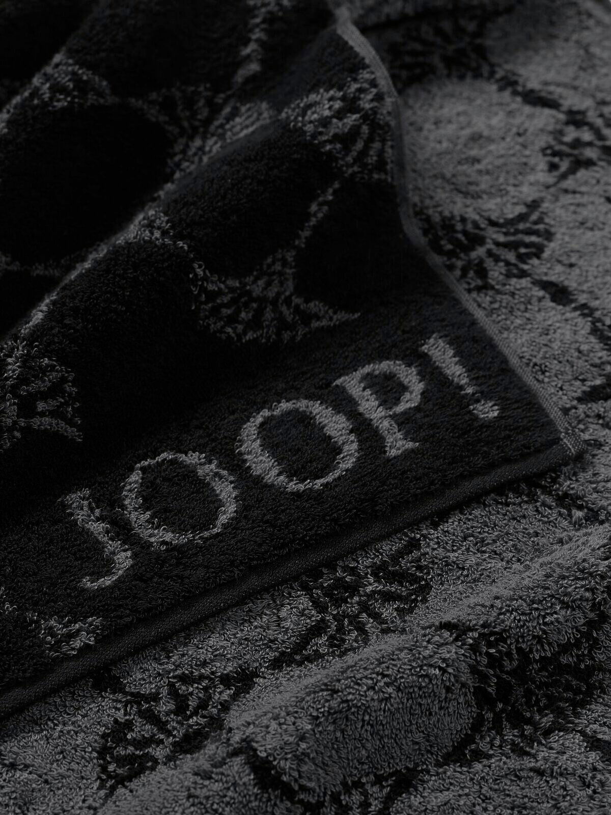Nahaufnahme eines luxuriösen, dunkelgrauen Handtuchs mit eingewebtem Muster und dem Schriftzug 'JOOP!'