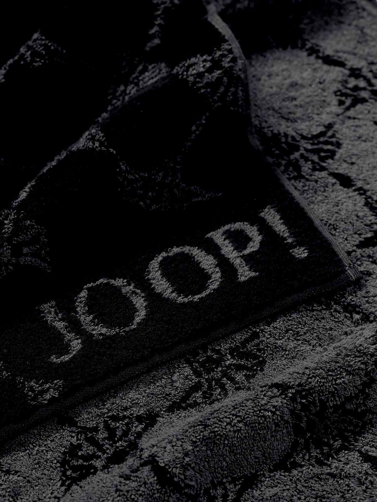 JOOP! Handtuch CORNFLOWER CLASSIC Nahaufnahme eines luxuriösen, dunkelgrauen Handtuchs mit eingewebtem Muster und dem Schriftzug 'JOOP!'
