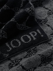 Nahaufnahme eines luxuriösen, dunkelgrauen Handtuchs mit eingewebtem Muster und dem Schriftzug 'JOOP!'