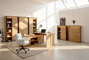 Modernes Büromöbel-Set aus naturbelassenem Holz mit Schreibtisch, Stauraumschränken und offenen Regalfächern, aus schräger Frontperspektive in einem hellen Homeoffice präsentiert.