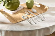 Besteckset Boston 60-tlg. auf einem Holztablett mit grünen Vasen, von oben fotografiert.