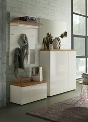 Moderne Garderobeneinrichtung mit weißem Hochglanz-Schuhschrank, passendem Garderobenpaneel und Spiegel, seitliche Perspektive