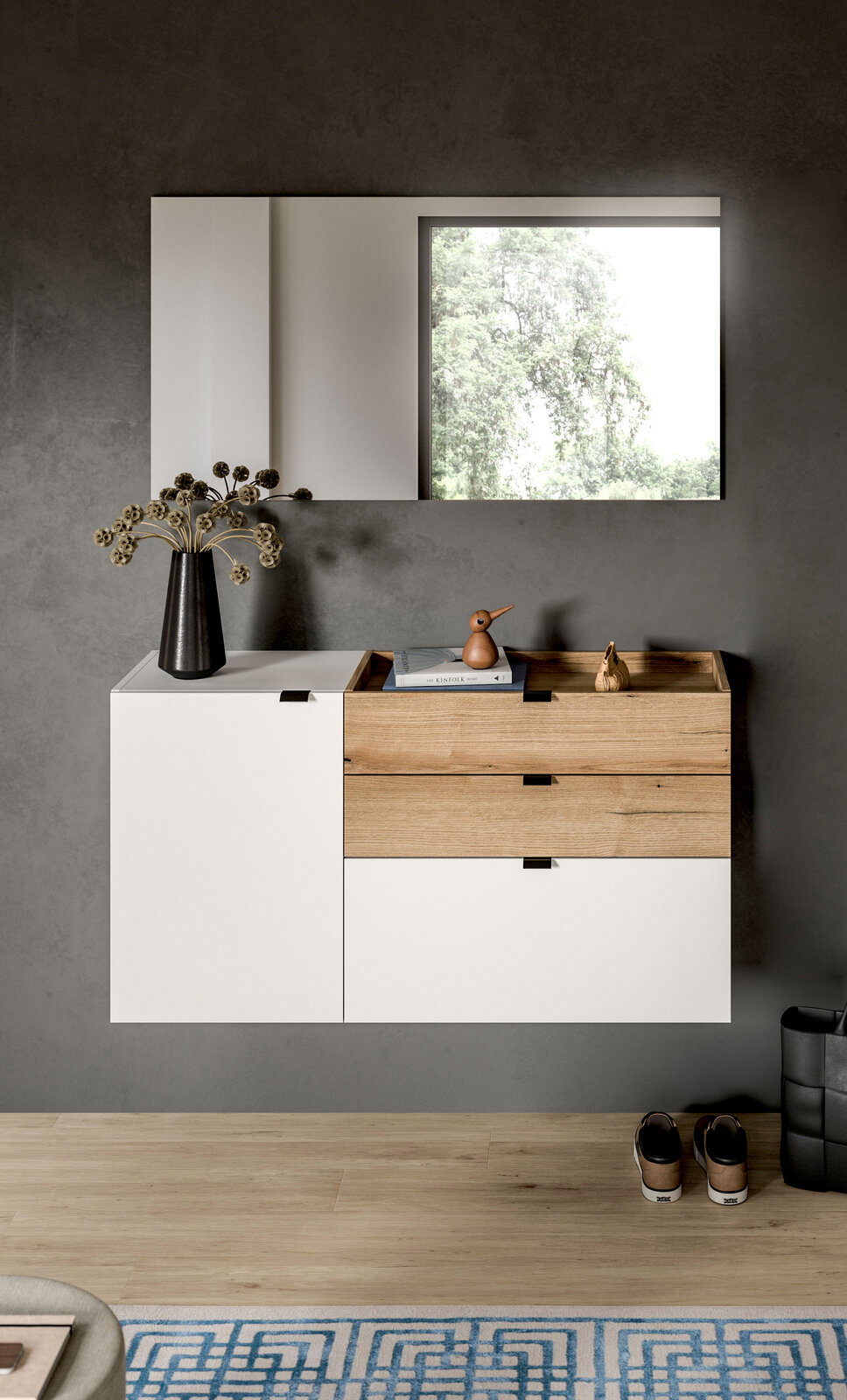 Modernes, wandhängendes Sideboard in Weiß und Eiche mit Schubladen und Ablage, dekoriert mit Vase, Büchern und Holzfigur, vor grauer Wand mit Spiegel – Frontalansicht.