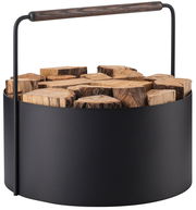 Moderner Feuerholz-Korb Ashi aus schwarzem Metall mit Holzgriff, gefüllt mit Holzscheiten, seitliche Perspektive.