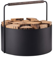 Moderner Feuerholz-Korb Ashi aus schwarzem Metall mit Holzgriff, gefüllt mit Holzscheiten, seitliche Perspektive.