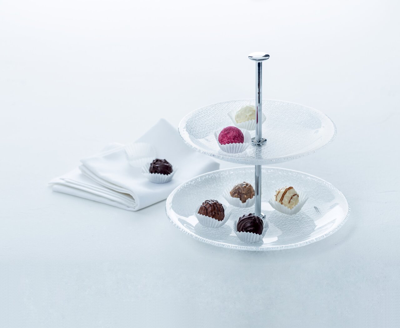 Zweistöckige Glas-Etagere Pralina mit Pralinen, seitliche Perspektive