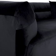 Nahaufnahme eines schwarzen Big-Sofas mit weichem Stoffbezug, seitliche Perspektive.