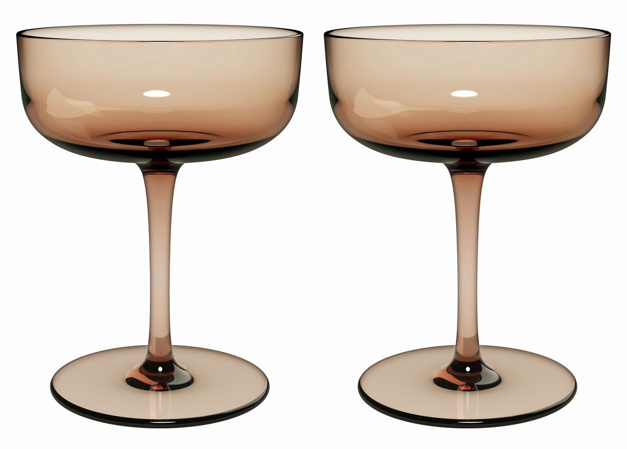 Zwei elegante Sekt- oder Dessertschalen aus Glas in einem warmen, bernsteinfarbenen Ton, frontal nebeneinander stehend.