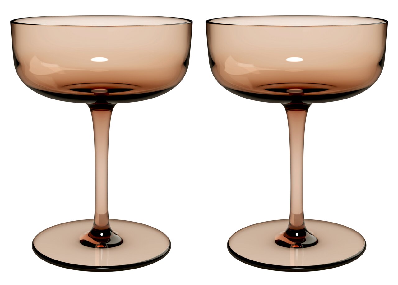 Zwei elegante Sekt- oder Dessertschalen aus Glas in einem warmen, bernsteinfarbenen Ton, frontal nebeneinander stehend.