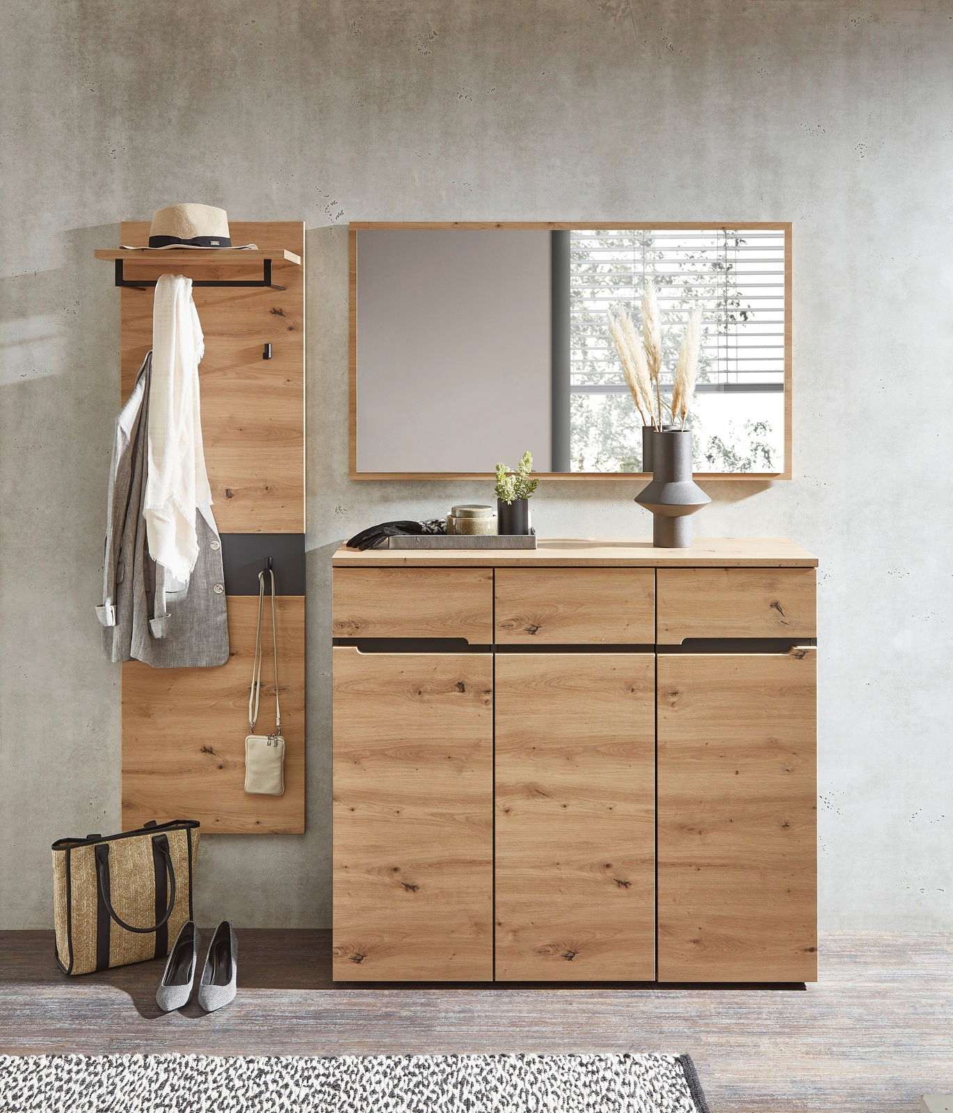 Garderoben-Set aus Holz in moderner Optik, bestehend aus einem Wandpaneel mit Haken und Ablage, einem großen Spiegel und einem geräumigen Schrank mit Schubladen, frontal betrachtet.