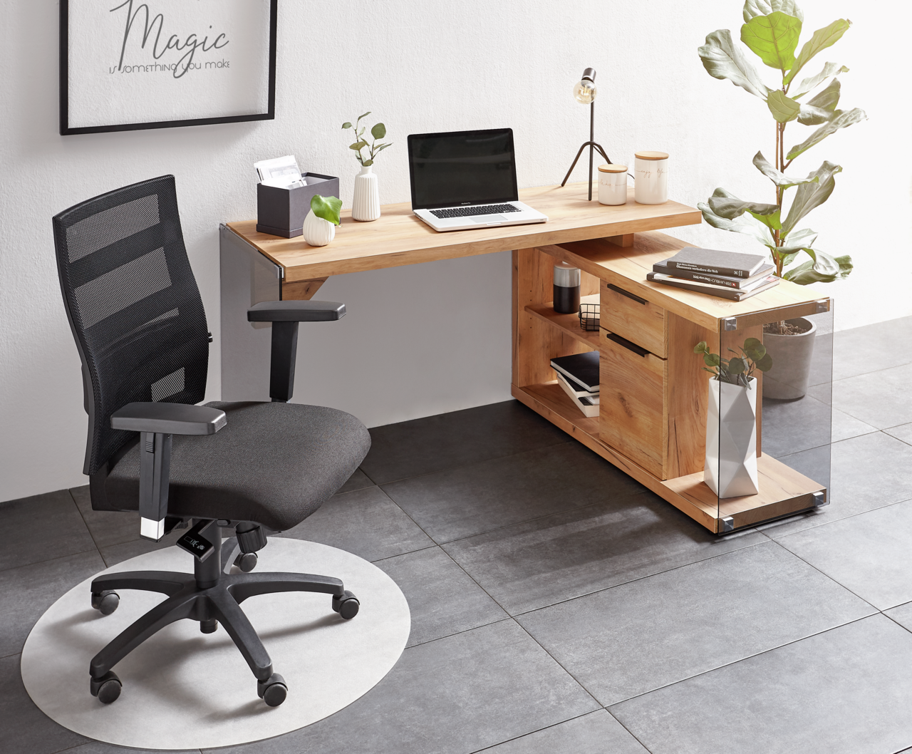 Moderner Drehstuhl in schwarzem Design, seitliche Perspektive, vor einem Schreibtisch mit Laptop und Pflanzen.