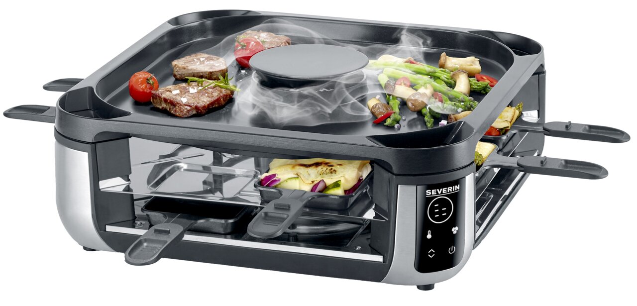 Rookloze raclettegrill met digitale bediening, gefotografeerd vanuit een schuine hoek van bovenaf, met daarop het grilloppervlak met vlees en groenten en daaronder de pannetjes.