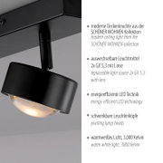 Moderne schwarze Deckenleuchte aus der SCHÖNER WOHNEN Kollektion mit schwenkbarem Spot und warmweißem LED-Licht (3000 K), Detailaufnahme in leicht seitlicher Untersicht.