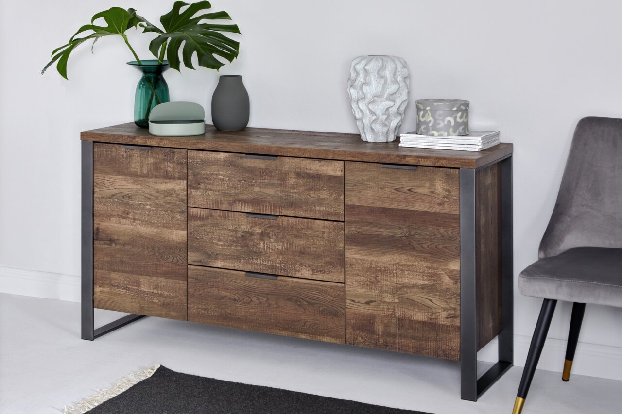Jahnke Sideboard LOOP Holz-Sideboard mit drei Schubladen und zwei Türen, dekoriert mit Vasen und Pflanzen, aus seitlicher Perspektive fotografiert.
