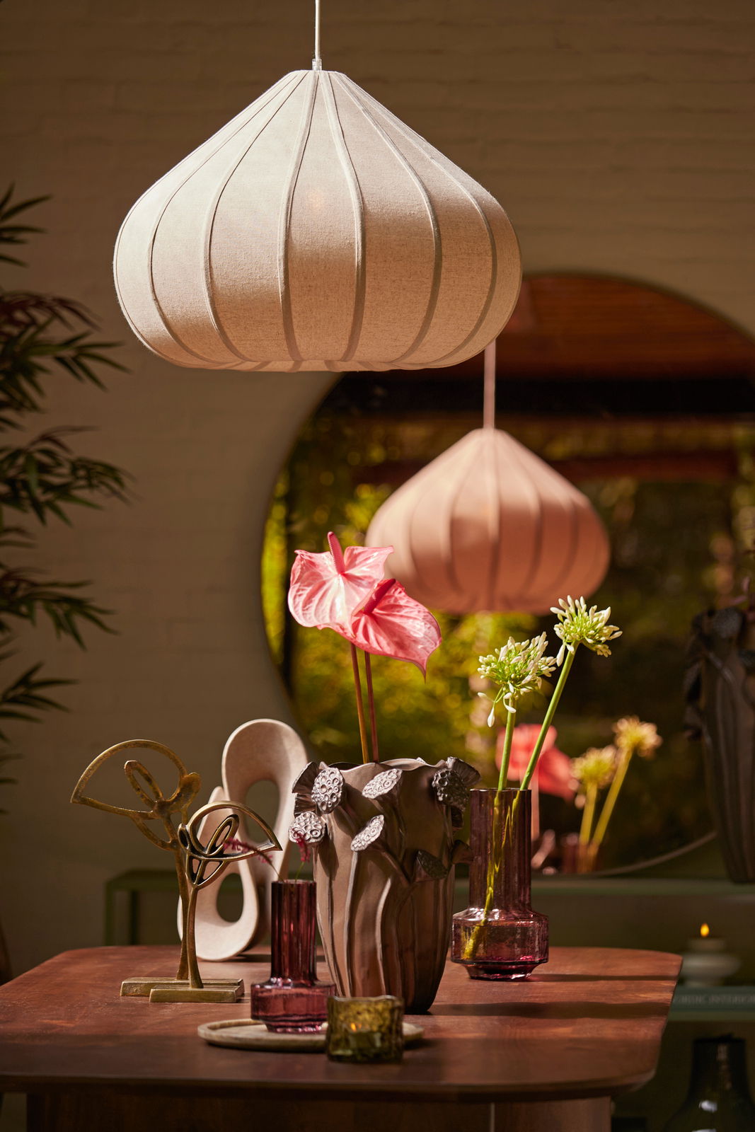 Vase mit floralen Verzierungen auf einem Tisch, umgeben von dekorativen Elementen, aus der Frontalperspektive betrachtet.