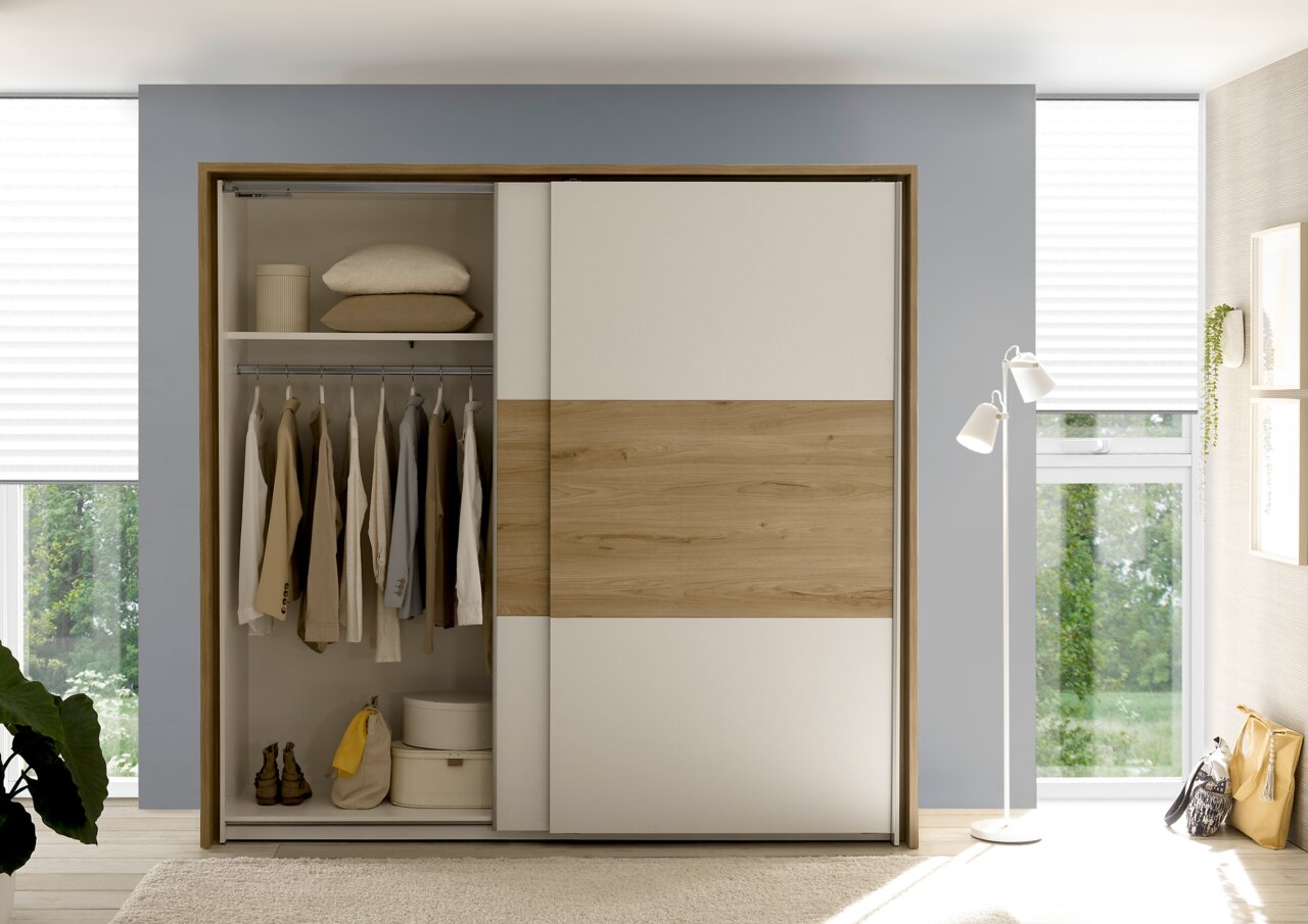 Moderner Kleiderschrank mit Schiebetüren in Holzoptik, teilweise geöffnet, mit Kleidung und Accessoires, aus der Frontalperspektive fotografiert.