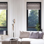 Moderne LED-Stehleuchte mit geschwungenem Design in einem eleganten Wohnzimmer, seitliche Perspektive.