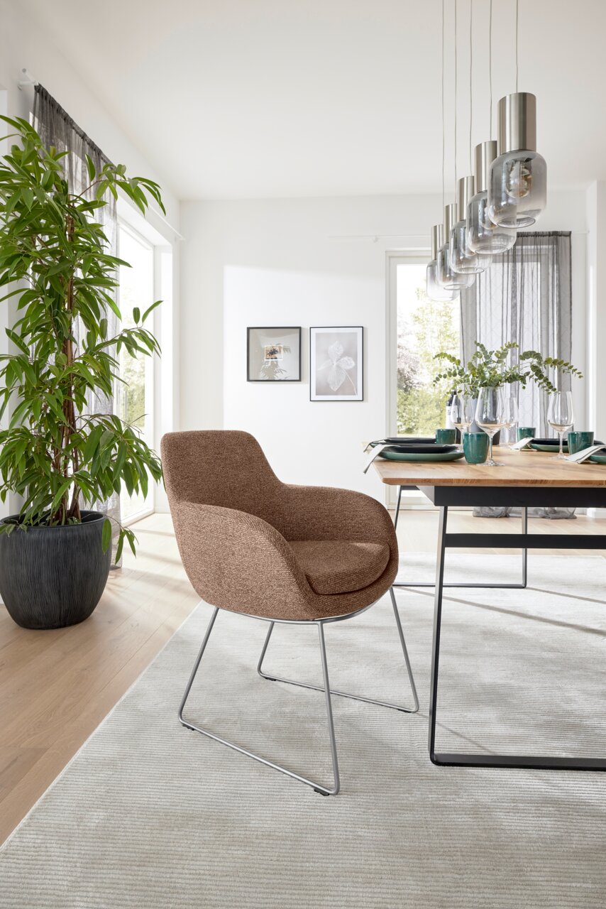 Moderner Armlehnstuhl in einem hellen Esszimmer, seitliche Perspektive