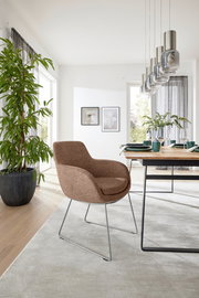 Moderner Armlehnstuhl in einem hellen Esszimmer, seitliche Perspektive