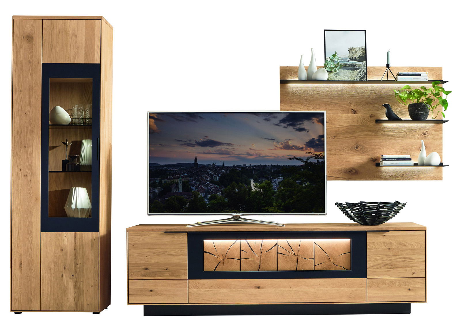 Wandkombination aus Holz mit modernem Design, bestehend aus einem hohen Schrank mit Glastür, einem TV-Board mit dekorativer Frontbeleuchtung und einem Wandregal mit Dekorationen. Perspektive: Frontalansicht.