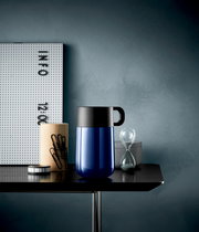 Impulse Travel Mug 0,3l Cromar in Blau mit schwarzem Deckel, seitliche Perspektive auf einem Tisch mit Büroaccessoires.