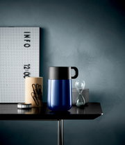 Impulse Travel Mug 0,3l Cromar in Blau mit schwarzem Deckel, seitliche Perspektive auf einem Tisch mit Büroaccessoires.