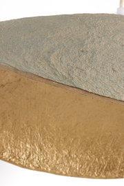 Nahaufnahme einer Hängeleuchte mit strukturierter Oberfläche in Grau und Gold, seitliche Perspektive