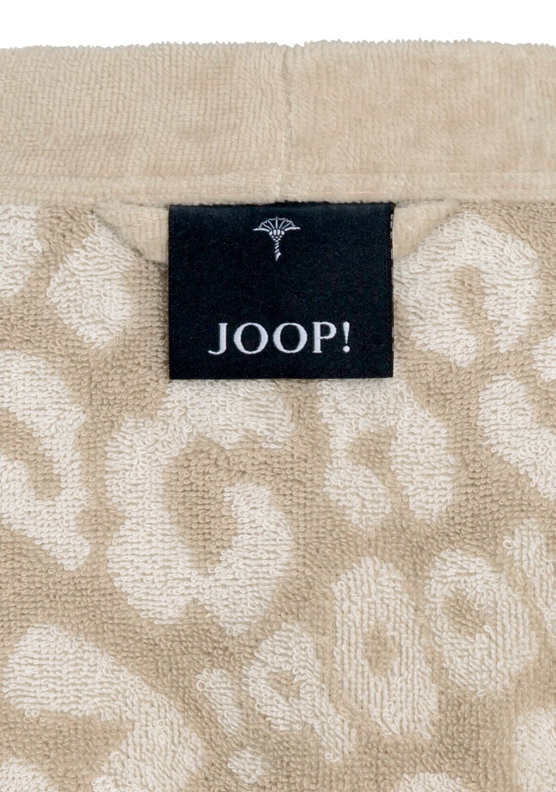 Close-up van een beige badjas met een zwart JOOP!-label in het midden.