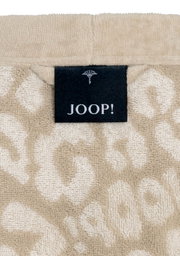 Close-up van een beige badjas met een zwart JOOP!-label in het midden.