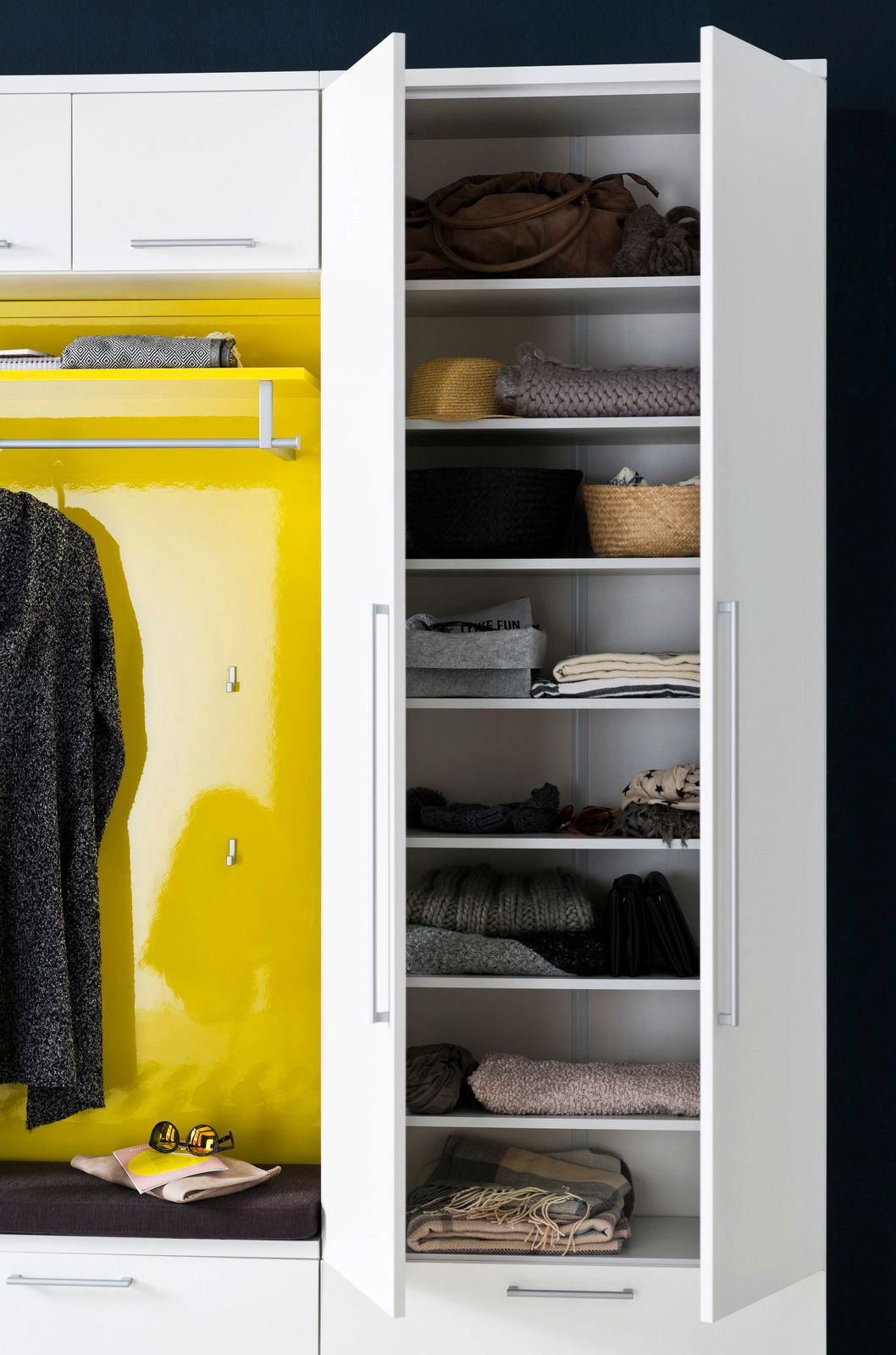 Garderobenschrank mit offenen Türen, gefüllt mit Kleidung und Accessoires, von vorne betrachtet.