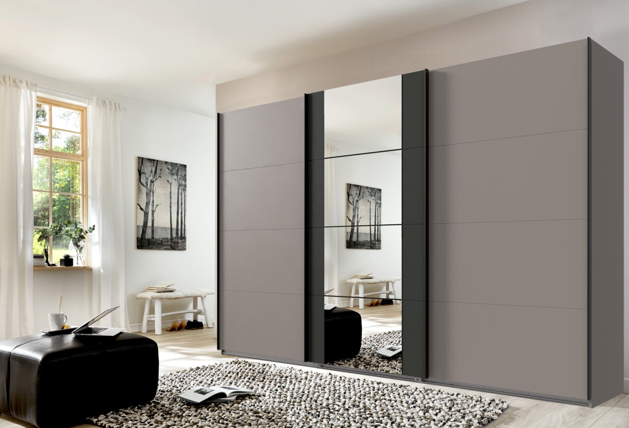 Moderner dreitüriger Schwebetürenschrank mit Spiegel in einem hellen Raum, seitliche Perspektive.