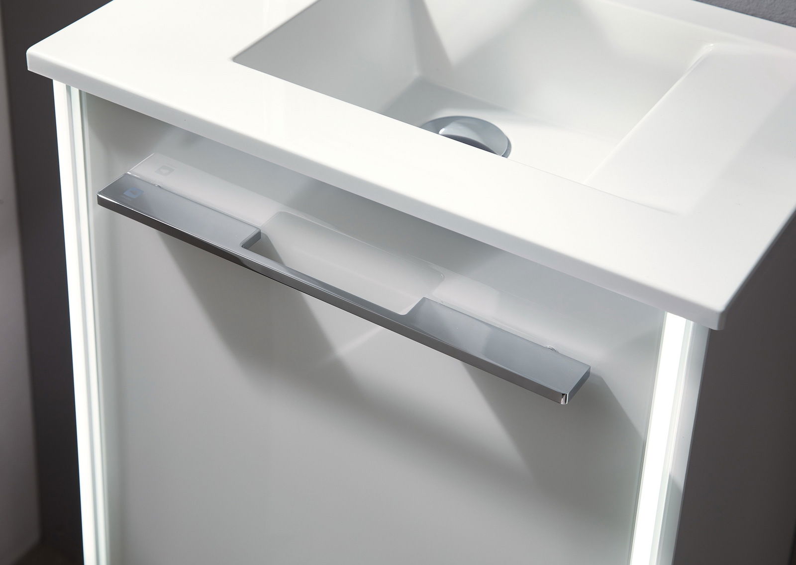 Moderner Waschtisch mit integriertem Waschbecken und eleganter Chromleiste, aus der Vogelperspektive fotografiert.