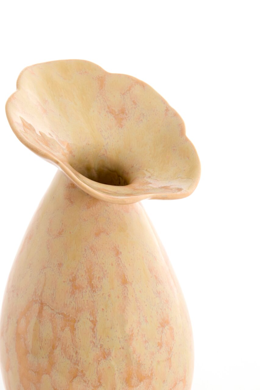 Nahaufnahme einer eleganten Vase mit blumiger Öffnung und marmorierter Oberfläche in sanften Gelb- und Orangetönen, seitliche Perspektive.