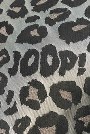 Nahaufnahme einer Zierkissenhülle mit Leopardenmuster und dem Schriftzug 'JOOP!' in der Mitte.