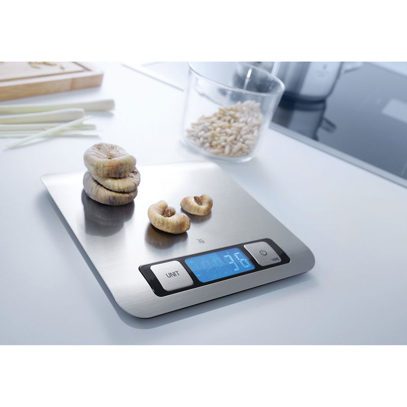 Digitale Küchenwaage in Silber mit blauer LED-Anzeige, von oben fotografiert, mit getrockneten Feigen darauf.