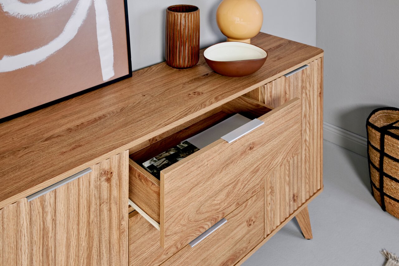 Holz-Sideboard mit Schubladen, dekoriert mit Vasen und Schalen, aus seitlicher Perspektive