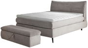 Boxspringbett 180x200 in grauem Stoff mit passendem Hocker, seitliche Perspektive