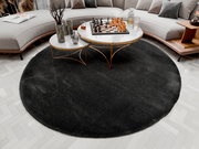Runder Hochflor-Teppich in dunklem Grau, platziert in einem modernen Wohnzimmer mit einem eleganten Couchtisch und einem Schachspiel darauf, aus der Vogelperspektive betrachtet.