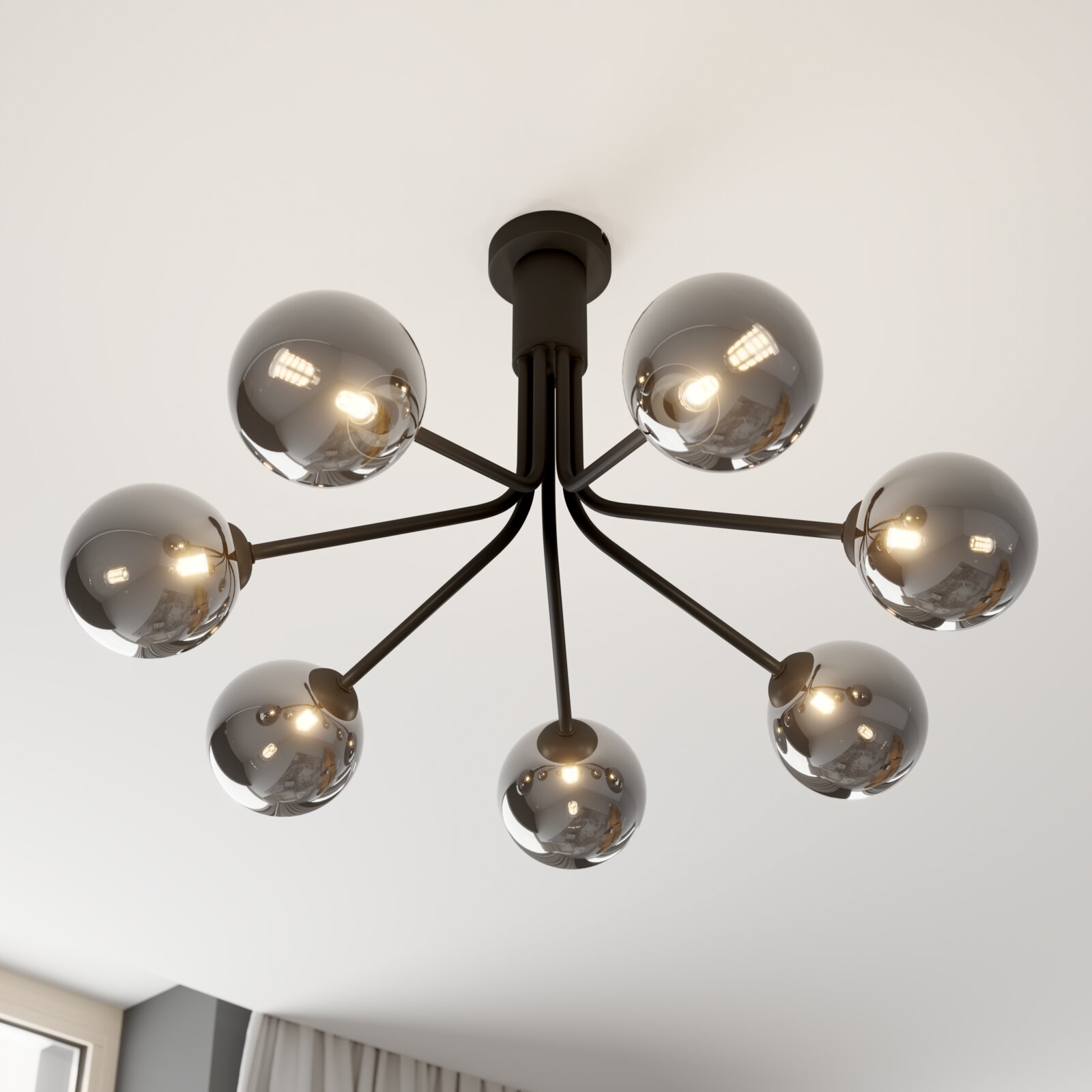 Moderne zwarte plafondlamp met zeven armen en rookgrijze glazen bolkappen, ingeschakeld, gezien van onderaf in een lichte ruimte