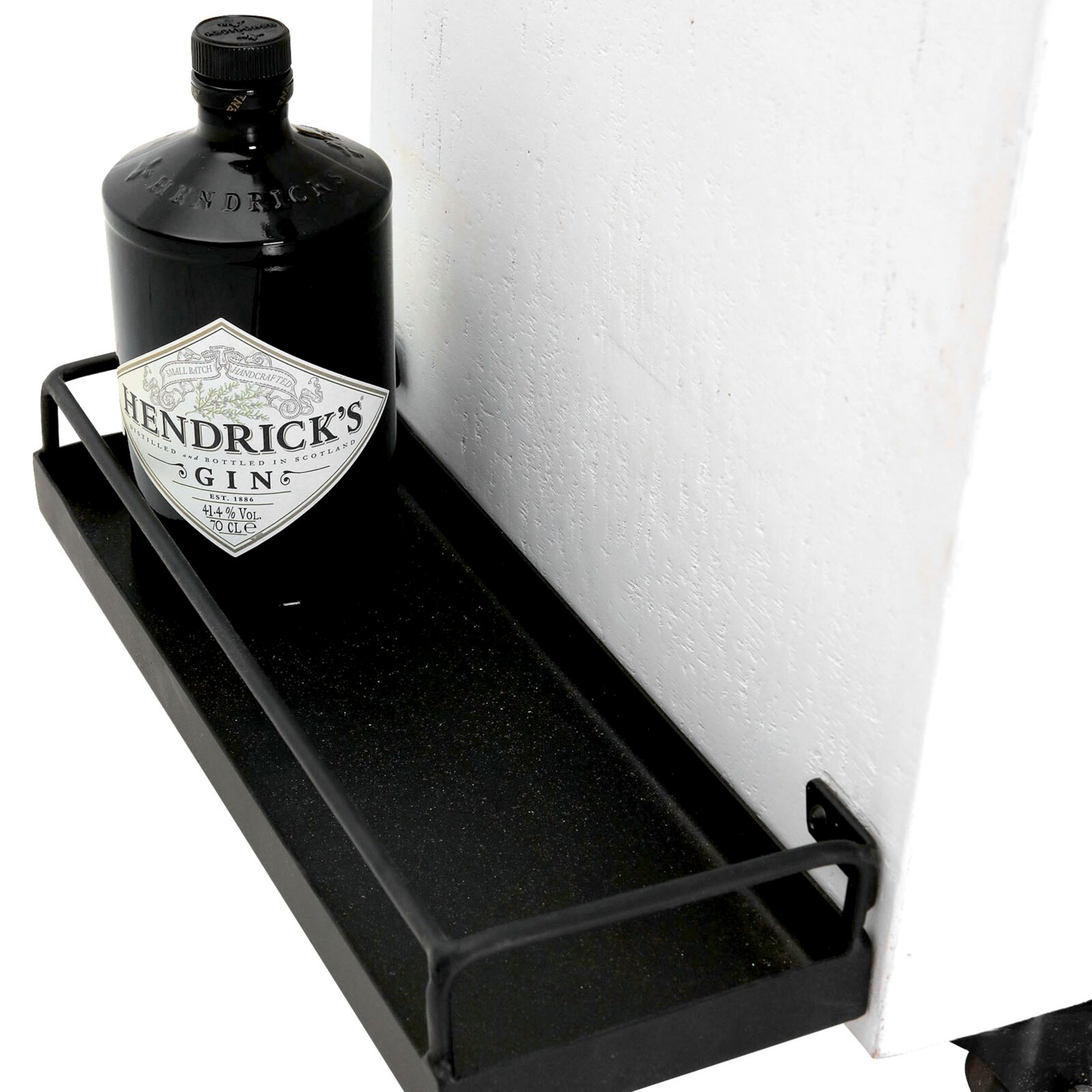 Close-up van een barwagen met een fles gin op een zwart metalen rek, gezien vanuit de zijkant.