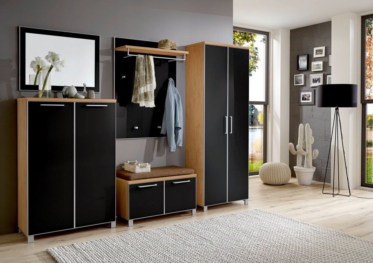 Modernes Garderoben-Set in Holzoptik mit schwarzen Fronten, bestehend aus Schrank, Sitzbank, Spiegel und Hakenleiste, seitliche Perspektive.