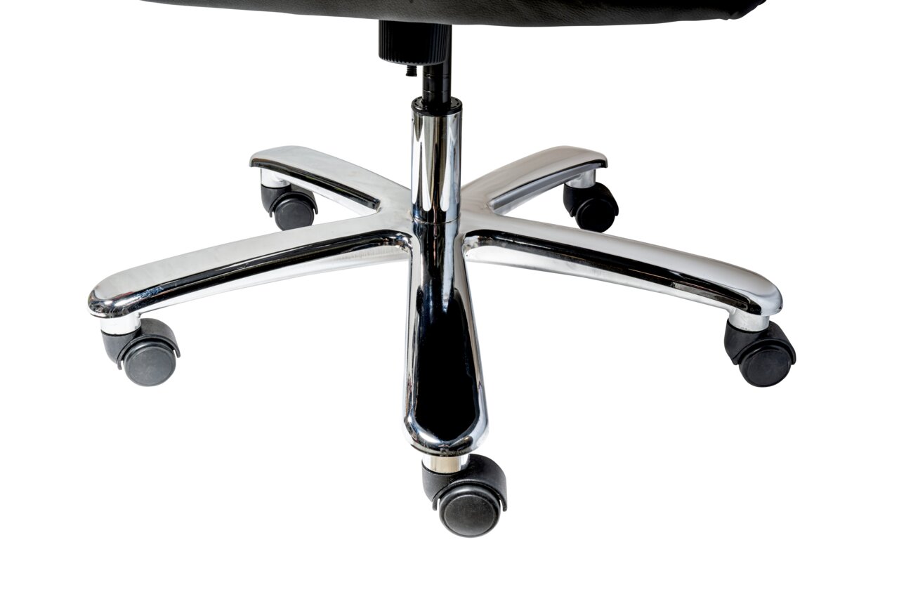 Nahaufnahme der Basis eines Chefsessels mit verchromtem Fußkreuz und Rollen, von unten fotografiert.