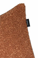 Nahaufnahme einer braunen Zierkissenhülle mit strukturierter Oberfläche und einem schwarzen Etikett mit der Aufschrift 'JOOP!'