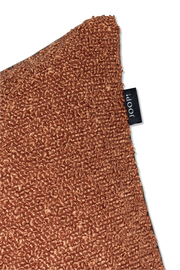 Nahaufnahme einer braunen Zierkissenhülle mit strukturierter Oberfläche und einem schwarzen Etikett mit der Aufschrift 'JOOP!'